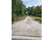 Gravel driveway and grassy terrain on land plot bordered by trees and fencing on a sunny day at 111 Beasley Rd, Oviedo, FL 32765