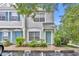 Inviting townhouse featuring a charming, light teal-colored front door and lush landscaping at 1150 Vineland Pl, Lake Mary, FL 32746