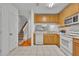 Bright kitchen features wood cabinets, white appliances, and a tiled floor at 1150 Vineland Pl, Lake Mary, FL 32746