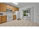 Bright kitchen featuring tile floors, white appliances, and sliding door access to patio at 1150 Vineland Pl, Lake Mary, FL 32746