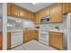Well-lit kitchen with wooden cabinetry, white appliances, and tile flooring at 1150 Vineland Pl, Lake Mary, FL 32746