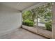 Screened patio enclosed by glass and white trim with concrete floors, textured wall, and neighborhood views at 1150 Vineland Pl, Lake Mary, FL 32746