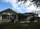 View of the rear of the home with an enclosed screened patio and a well-manicured lawn at 11540 Sandy Hill Dr, Orlando, FL 32821