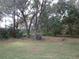 View of the home's well-manicured backyard, bordered by mature trees and natural landscaping at 11540 Sandy Hill Dr, Orlando, FL 32821