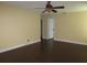 A bedroom with dark wood-look floors, a ceiling fan, and access to the bathroom at 11540 Sandy Hill Dr, Orlando, FL 32821