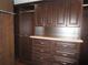View of a custom closet with built-in dark wood cabinets, shelves, and a countertop at 11540 Sandy Hill Dr, Orlando, FL 32821