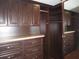 Custom walk-in closet with dark wood cabinets, drawers, and ample storage space at 11540 Sandy Hill Dr, Orlando, FL 32821