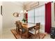 A formal dining room with a wood table, neutral chairs, red drapes, and a decorative rug at 11706 Waterstone Loop Dr, Windermere, FL 34786