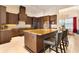 A gourmet kitchen with dark wood cabinets, granite countertops, stainless steel appliances and seating at the island at 11706 Waterstone Loop Dr, Windermere, FL 34786