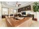 An elegant living room featuring a stone fireplace, built-in shelving, and a plush leather sectional sofa at 11706 Waterstone Loop Dr, Windermere, FL 34786