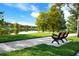 Scenic park view featuring a park bench, lush landscaping, and a tranquil lake reflecting the surrounding trees at 11706 Waterstone Loop Dr, Windermere, FL 34786