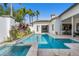 Backyard pool and spa featuring travertine tile, lush tropical landscaping and a beautiful architectural design at 11706 Waterstone Loop Dr, Windermere, FL 34786