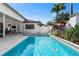 Backyard oasis featuring a sparkling pool, lush tropical foliage, and a pristine white privacy fence at 11706 Waterstone Loop Dr, Windermere, FL 34786