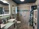 Stylish bathroom with a double vanity, decorative mirror, tiled shower, and patterned shower curtain at 1203 Monterey Dr, Eustis, FL 32726
