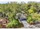 Aerial view of a charming blue home with a long driveway and mature trees at 1203 W 16Th St, Sanford, FL 32771