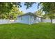 Backyard view showing the green grass, white fence, concrete patio, and blue house at 1203 W 16Th St, Sanford, FL 32771