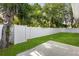 Backyard view showing the green grass, white fence, concrete patio, and trees at 1203 W 16Th St, Sanford, FL 32771