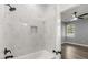 Walk in shower featuring marble tiling and black fixtures, leading to a room with wood floors at 1203 W 16Th St, Sanford, FL 32771