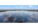Panoramic aerial view of a serene lake surrounded by lush greenery and a clear blue sky at 13427 Blue Heron Beach Dr # 1907, Orlando, FL 32821