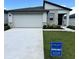 Charming single-story home featuring a stone facade, a two-car garage, and a well-manicured lawn at 1392 Dalkeith Cv, Sanford, FL 32771