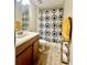 Cozy bathroom with decorative sunburst patterned shower curtain and tile flooring at 1474 Lake Side Ave, Davenport, FL 33837