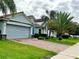 A beautiful house with a two-car garage, well-maintained lawn, and large palm trees in front at 1474 Lake Side Ave, Davenport, FL 33837