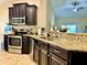 Modern kitchen featuring granite countertops, stainless steel appliances, and dark wood cabinets at 1474 Lake Side Ave, Davenport, FL 33837