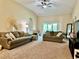 Bright and airy living room with comfortable seating, neutral tones, and a ceiling fan at 1474 Lake Side Ave, Davenport, FL 33837