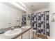 Bright bathroom featuring a double sink vanity and shower with decorative shower curtain at 149 Emeraldview Ave, Davenport, FL 33897