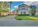 Charming two-story home with manicured lawn, lush landscaping, and concrete driveway in a sunny neighborhood at 149 Emeraldview Ave, Davenport, FL 33897