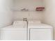 Efficient laundry area with a full-size washer and dryer and overhead shelving at 149 Emeraldview Ave, Davenport, FL 33897