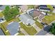 A high-angle view of the home showing the surrounding landscape, nearby houses, and cars parked in the driveways at 171 Seabreeze Cir, Kissimmee, FL 34743