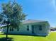 Landscaped backyard with green grass, shade tree, and a covered lanai at 1726 Brassie Ct, Kissimmee, FL 34746
