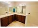 Bathroom with double vanity, granite countertop, and a tiled shower area at 1726 Brassie Ct, Kissimmee, FL 34746