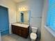 Well-lit bathroom with granite counters, wood cabinets, and a modern toilet at 1726 Brassie Ct, Kissimmee, FL 34746