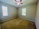 This is a bedroom with carpet and two windows with blinds. It also features a ceiling fan at 1726 Brassie Ct, Kissimmee, FL 34746
