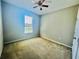 Clean, carpeted bedroom featuring a ceiling fan and natural light from a window at 1726 Brassie Ct, Kissimmee, FL 34746