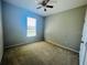 Neutral bedroom featuring carpet, a ceiling fan, and natural light from the window at 1726 Brassie Ct, Kissimmee, FL 34746