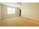 Spacious carpeted bedroom with a ceiling fan and a large window for natural light at 1726 Brassie Ct, Kissimmee, FL 34746