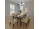 Charming dining room with a wood table set for six, enhanced by natural light and a modern chandelier at 1726 Brassie Ct, Kissimmee, FL 34746