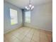 Bright dining room with tile flooring illuminated by a chandelier and natural light from two windows at 1726 Brassie Ct, Kissimmee, FL 34746