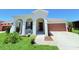 Charming home featuring an arched entryway and a two-car garage, all set on a beautifully landscaped lot at 1726 Brassie Ct, Kissimmee, FL 34746