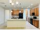 Spacious kitchen featuring a large island with granite countertops, wooden cabinetry and black appliances at 1726 Brassie Ct, Kissimmee, FL 34746