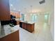 Open kitchen with granite countertops, a large island, wooden cabinetry, and black appliances at 1726 Brassie Ct, Kissimmee, FL 34746