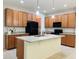 Modern kitchen with a central island, granite countertops, wooden cabinets, and black appliances at 1726 Brassie Ct, Kissimmee, FL 34746