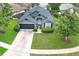 Aerial view of the home with a well-maintained lawn, beautiful landscaping, and a two-car garage at 1825 Needham Rd, Apopka, FL 32712