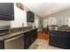 Well-equipped kitchen with granite counters, dark cabinets, stainless steel appliances, and view to dining room at 1825 Needham Rd, Apopka, FL 32712