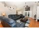 Bright living room boasts wood floors, ceiling fan, and comfortable blue leather furniture set around a dark coffee table at 1825 Needham Rd, Apopka, FL 32712