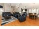 Open concept living room and dining area featuring wood floors and comfortable blue leather furniture at 1825 Needham Rd, Apopka, FL 32712