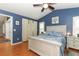 Comfortable main bedroom features blue walls, wood floors, ceiling fan, and a large window with curtains at 1825 Needham Rd, Apopka, FL 32712
